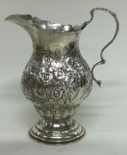 CHESTER: A silver cream jug with chased decoration.