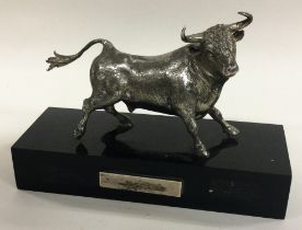A large silver figure of a bull on plinth.