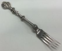A Victorian silver figural fork with embossed decoration. London 1852.