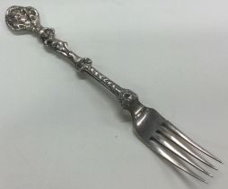 A Victorian silver figural fork with embossed decoration. London 1852.