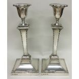 A fine pair of silver candlesticks with engraved borders. London 1909. By Stewart Dawson & Co Ltd.