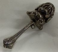 A silver rattle in the form of a bear.
