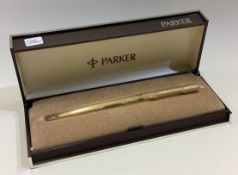 A heavy 9 carat engine turned Parker pen.