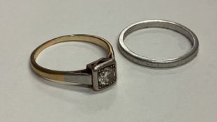 A small diamond single stone ring in 18 carat gold setting together with a platinum wedding band.