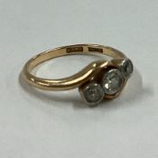 A small diamond three stone crossover ring in 18 carat gold setting.