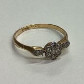A small diamond daisy head cluster ring in 18 carat gold setting.