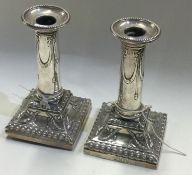 A pair of Victorian silver candlesticks with square bases. London 1900.