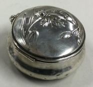 A decorative French silver box with hinged lid.