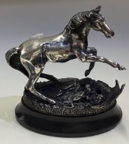 A silver figure of a horse with birds on plinth.