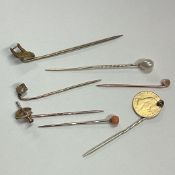 A group of gold stick pins.