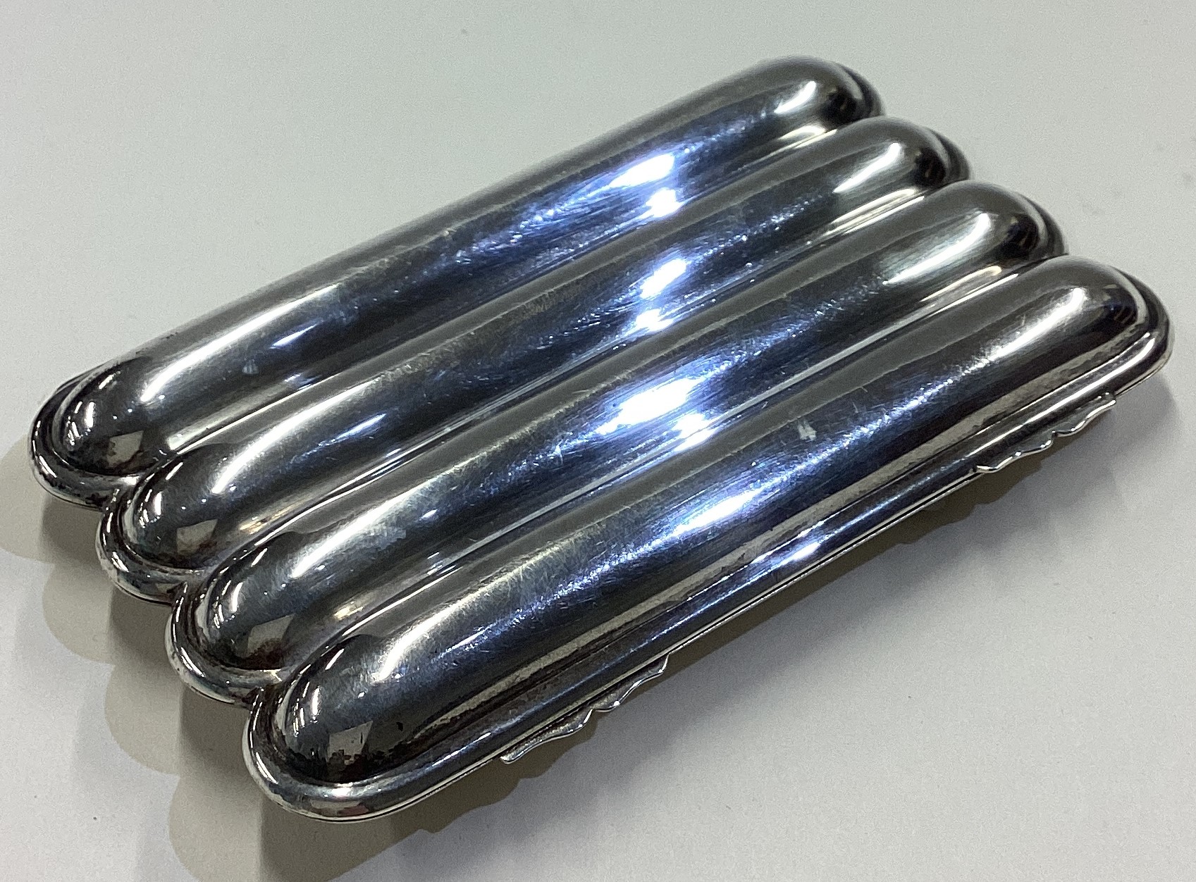 CHESTER: A plain silver cigar case.