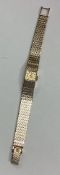 OMEGA: A lady's 9 carat wristwatch on panelled strap.