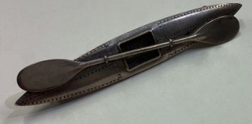 A silver brooch in the form of a canoe.