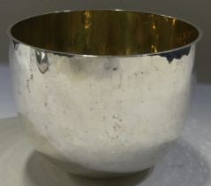 A large hammered silver tumbler cup with gilt interior.