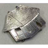 A Chinese silver menu holder in the form of a thatched cottage.