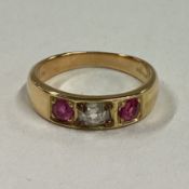 A diamond and ruby three stone gypsy set ring in 18 carat gold mount.