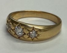 A diamond three stone gypsy set ring in 18 carat gold.