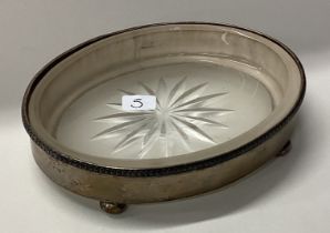 An oval silver and glass mounted butter dish.