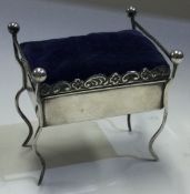 A rare silver combination pin cushion / jewellery box on four feet.