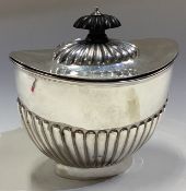 A silver tea caddy of fluted design with hinged lid. Sheffield 1906.