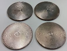 A set of four silver coasters.