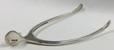 A pair of silver wishbone shaped ice tongs.