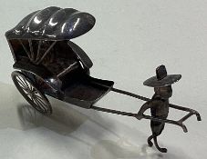 A Chinese silver miniature of a man and carriage.