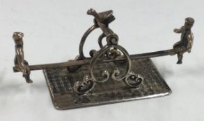 An Antique Dutch silver miniature table toy of men on a seesaw.