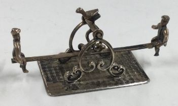 An Antique Dutch silver miniature table toy of men on a seesaw.