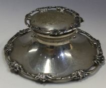 A decorative silver inkwell with pierced border.
