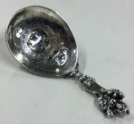 An Antique silver caddy spoon with figural handle and chased stag to centre.