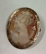 An oval gold framed cameo of a lady's head.