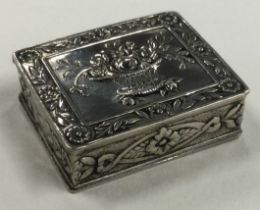 A Continental silver pill box with hinged lid and floral decoration.