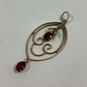 A small garnet two stone pendant in 9 carat scroll mount.