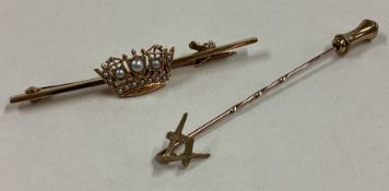 A small Masonic stick pin together with a gold brooch.