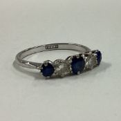 An attractive sapphire and diamond five stone half hoop ring in 18 carat white gold mount.