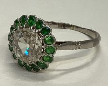 An attractive diamond and demantoid garnet cluster ring in platinum setting.