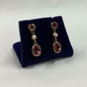 A good pair of garnet and pearl drop earrings in 9 carat mount.