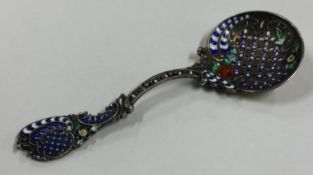 A silver and blue enamelled spoon with chased floral decoration.