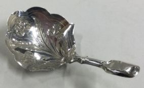 A Victorian silver caddy spoon with bright-cut decoration.