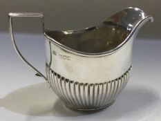 A fluted silver cream jug. London 1910. By Robert Pringle.