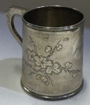 A Chinese export silver mug with engraved decoration.