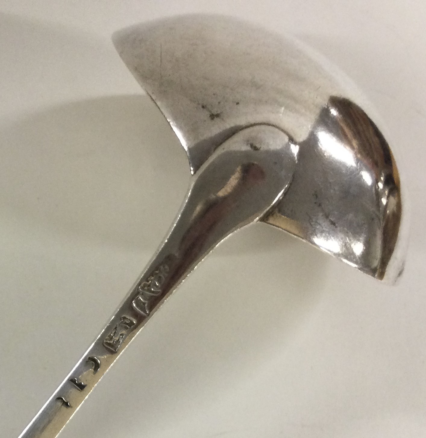 A bottom marked 18th Century crested silver soup ladle with feather edging. - Image 2 of 2