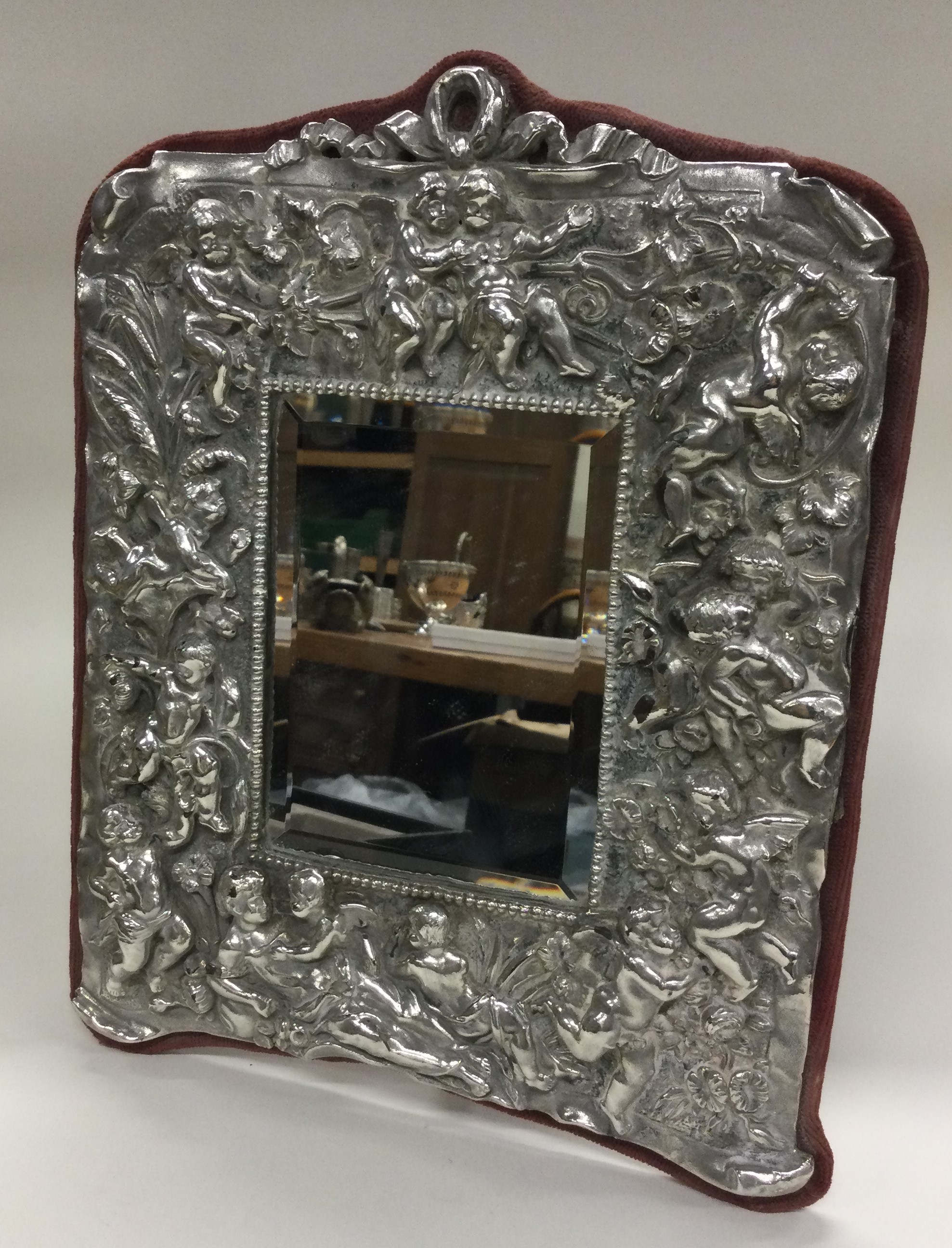 A silver backed mirror embossed with cherubs. - Image 2 of 2
