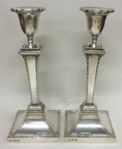 A fine pair of silver candlesticks with engraved borders. London 1909. By Stewart Dawson & Co Ltd.