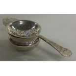 R E STONE: A contemporary silver tea strainer on stand. London 1948.