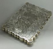 A Victorian silver card case engraved with village scene and engine turned flowers.
