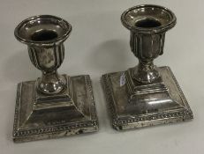 A pair of silver candlesticks on square bases. Birmingham 1909.