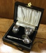 A silver plated egg cup, spoon and napkin ring set.