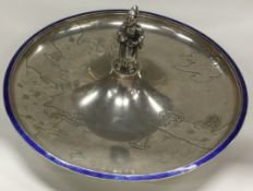 A Chinese export silver and enamelled dish chased with temples, flowers, boats and ducks.
